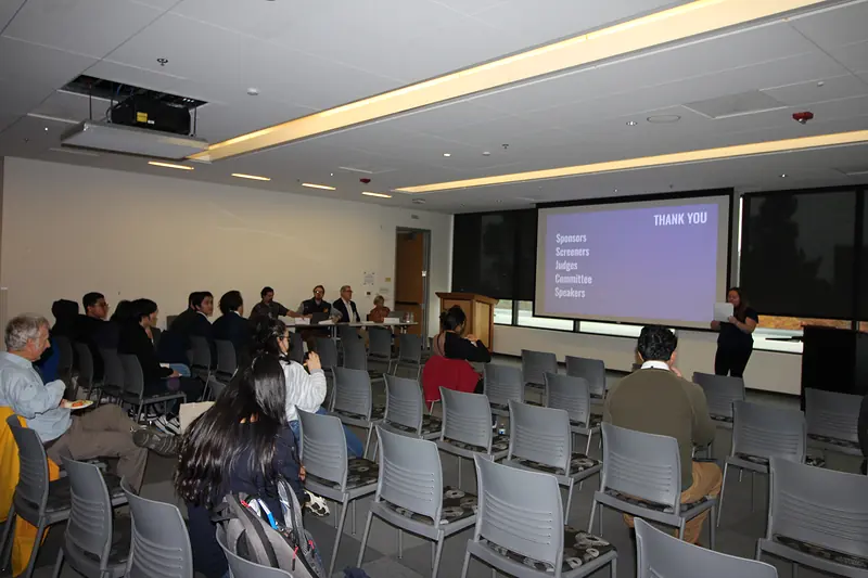 A wide view of the Diablo Room from the back during the closing slides, with the judging table at the front.