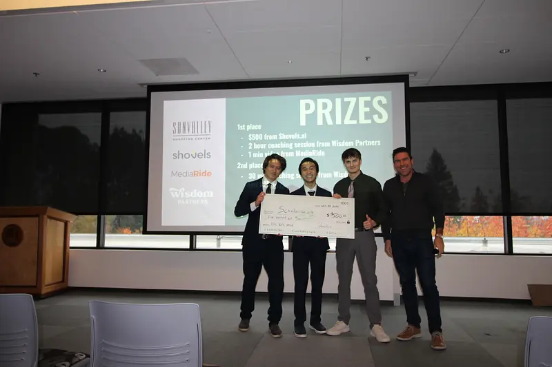 Three members of the Scholarise.org team holding an oversized $500 check with an organizer.